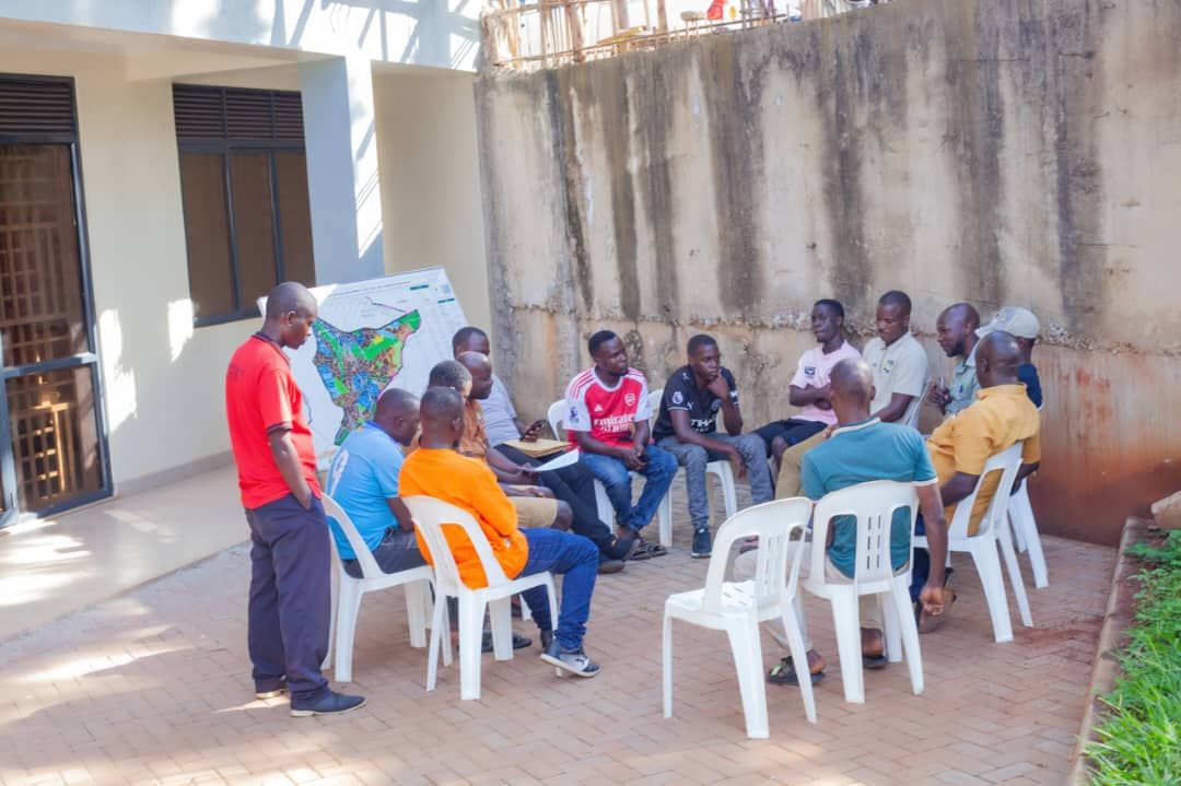 Football committee members seated in a circle outdoors during the planning meeting